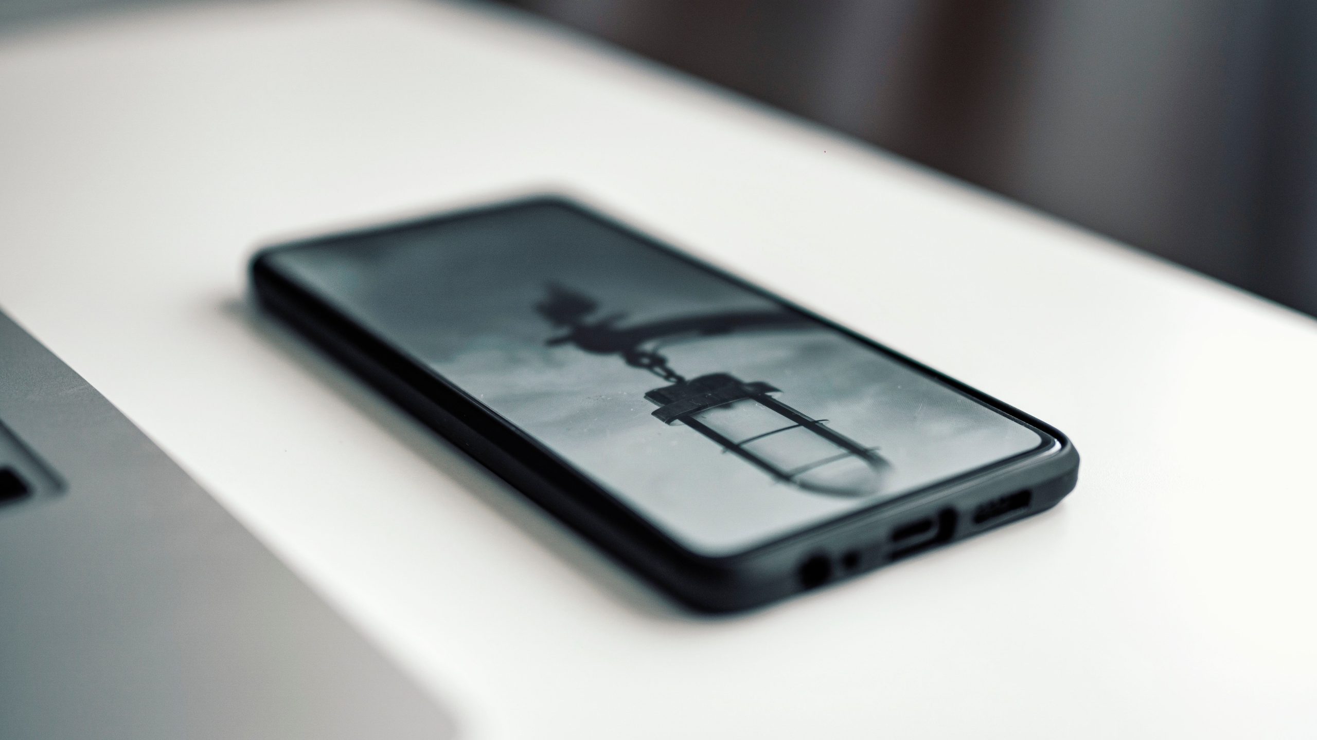 Smartphone affichant image floue près ordinateur