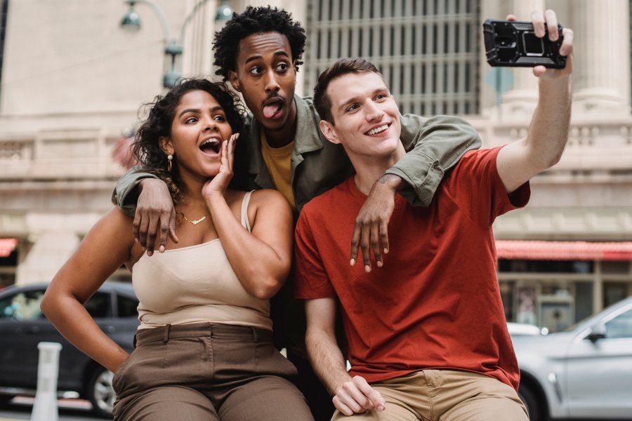 Amis multiethniques prenant selfie amusant en rue