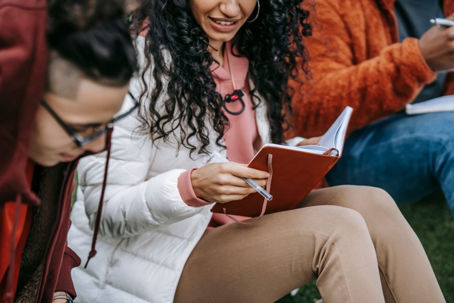 Étudiants multiculturels étudiant ensemble sur l'herbe