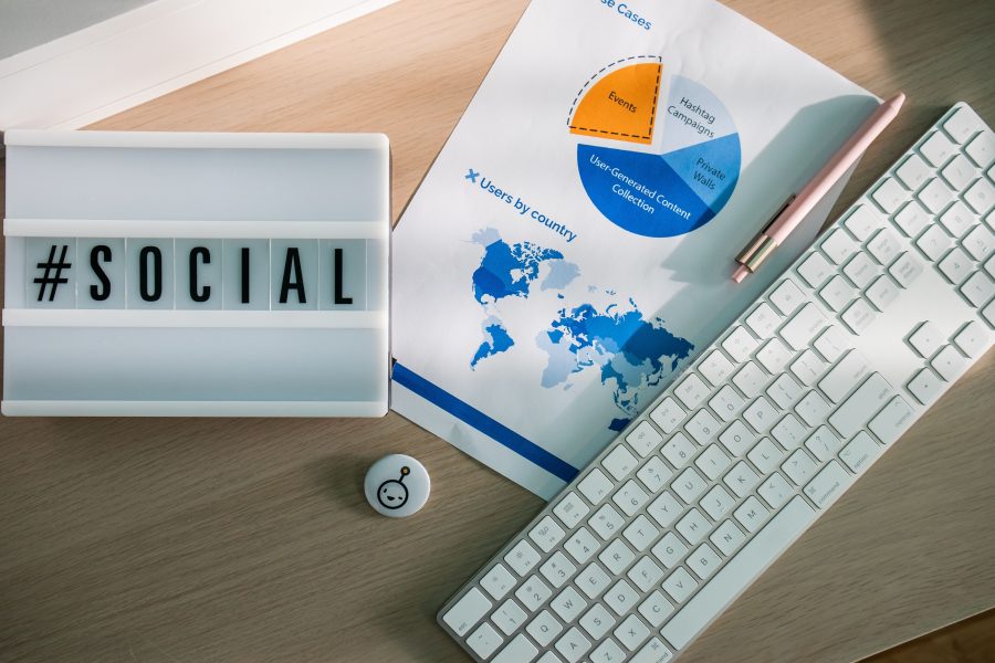 Bureau avec hashtags réseaux sociaux et graphiques analytiques