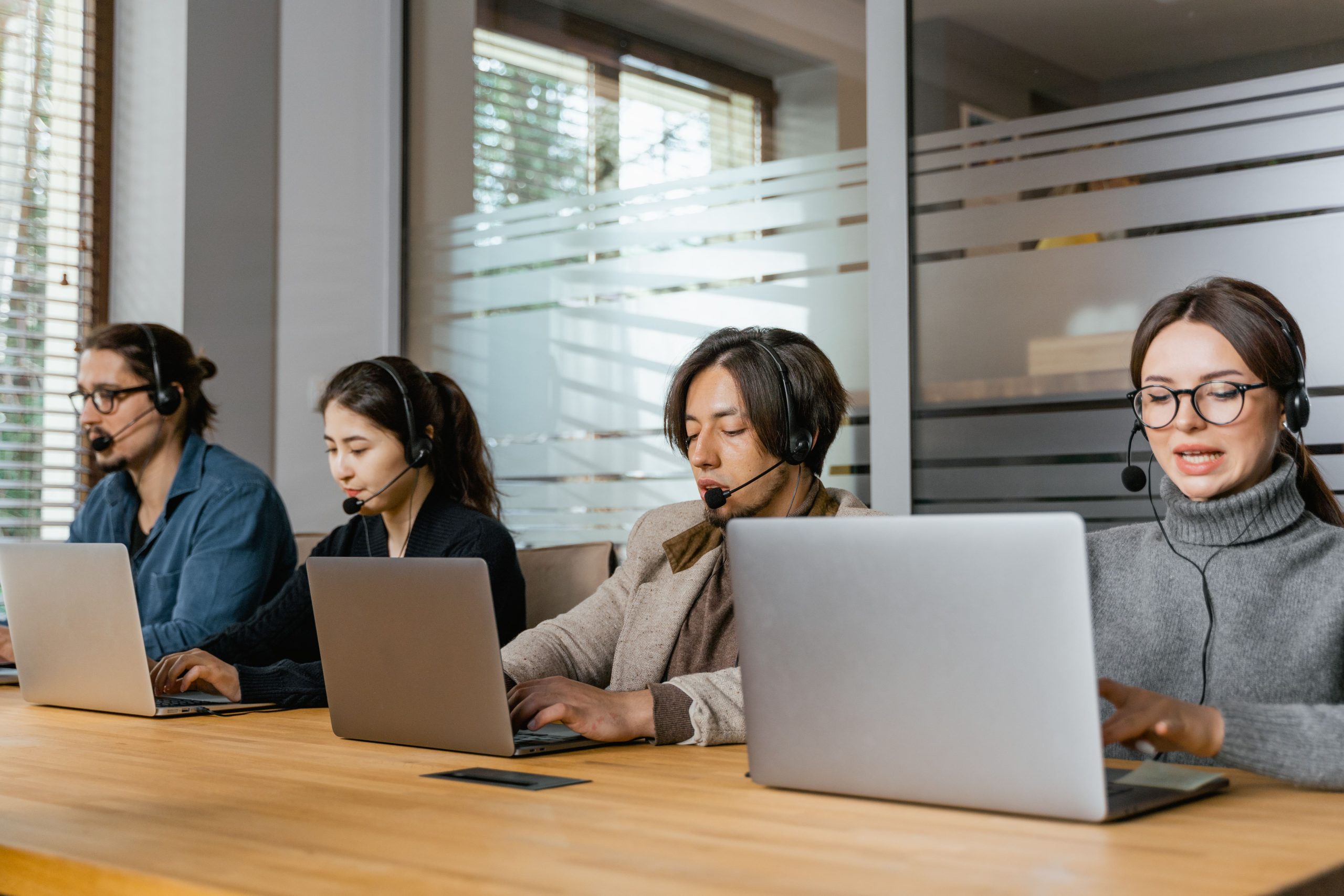 Quatre agents support client travaillant en bureau