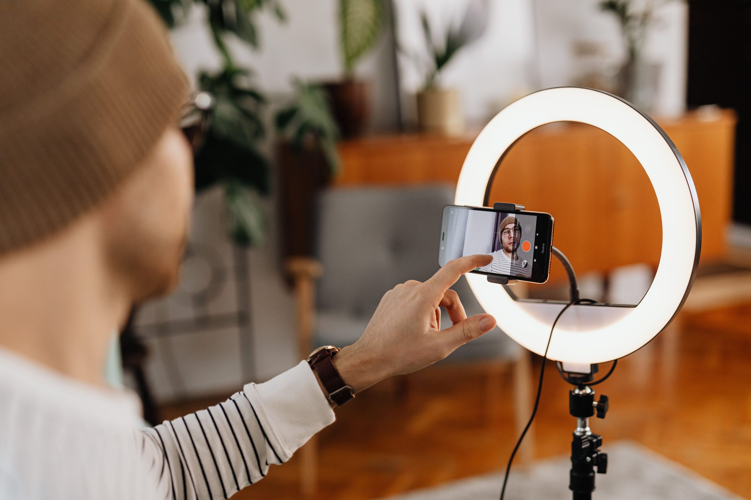 Homme créant vidéo avec smartphone et lampe