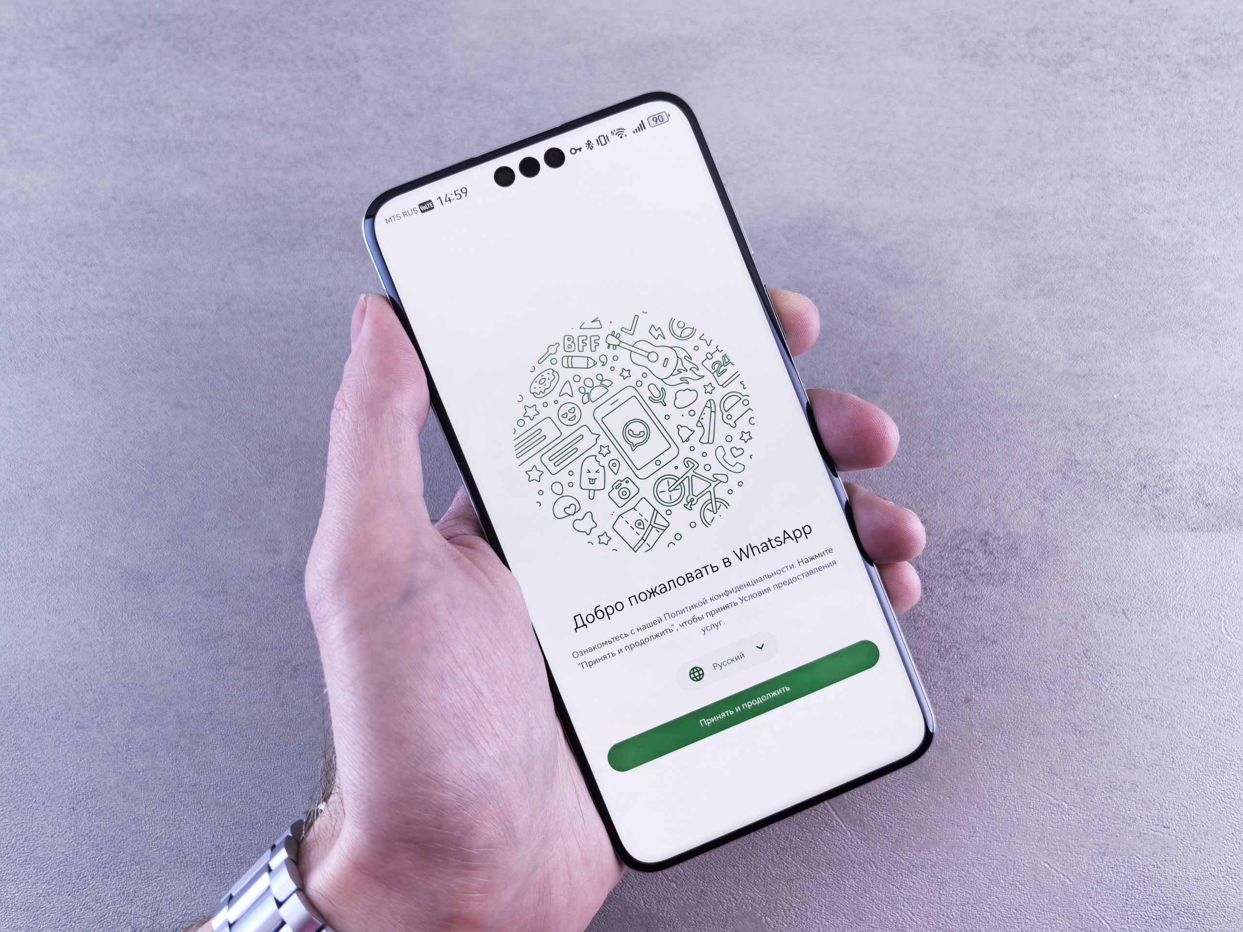 Main tenant smartphone avec écran WhatsApp russe