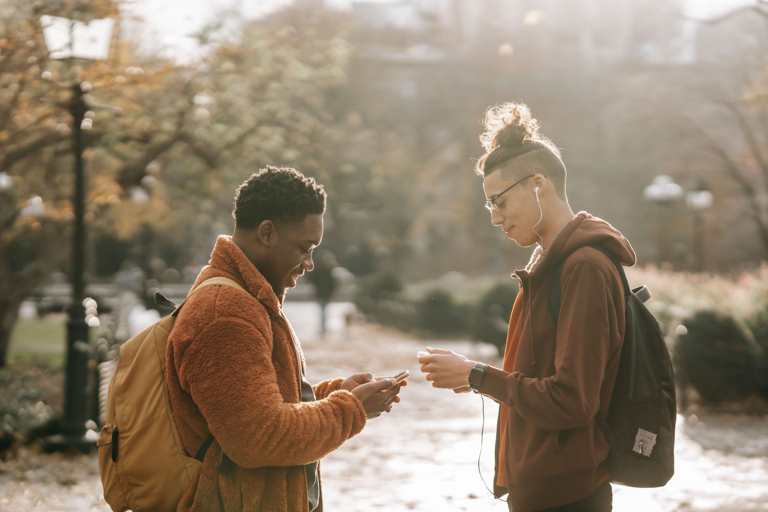 Jeunes amis discutant sur téléphone en parc automnal