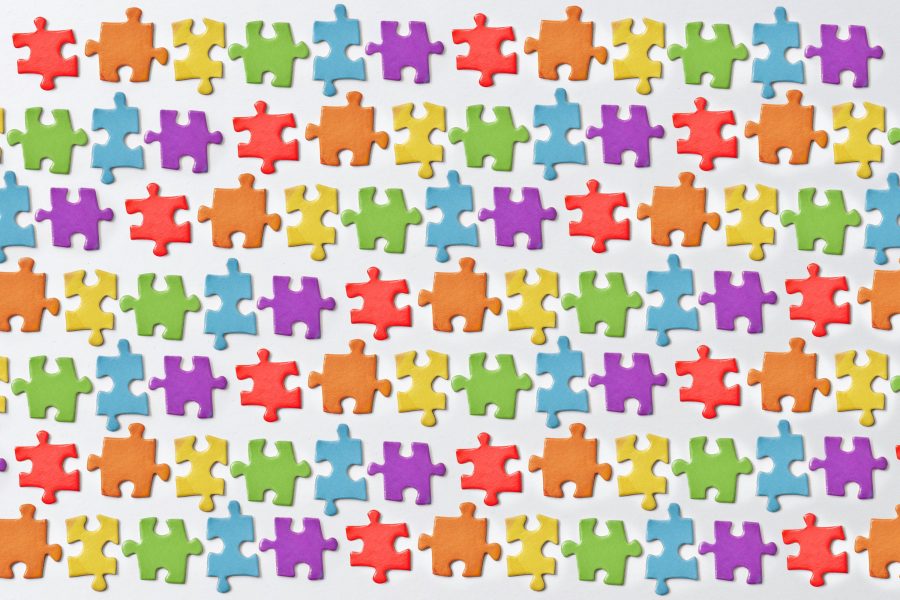 Pièces de puzzle colorées arrangées sur surface blanche