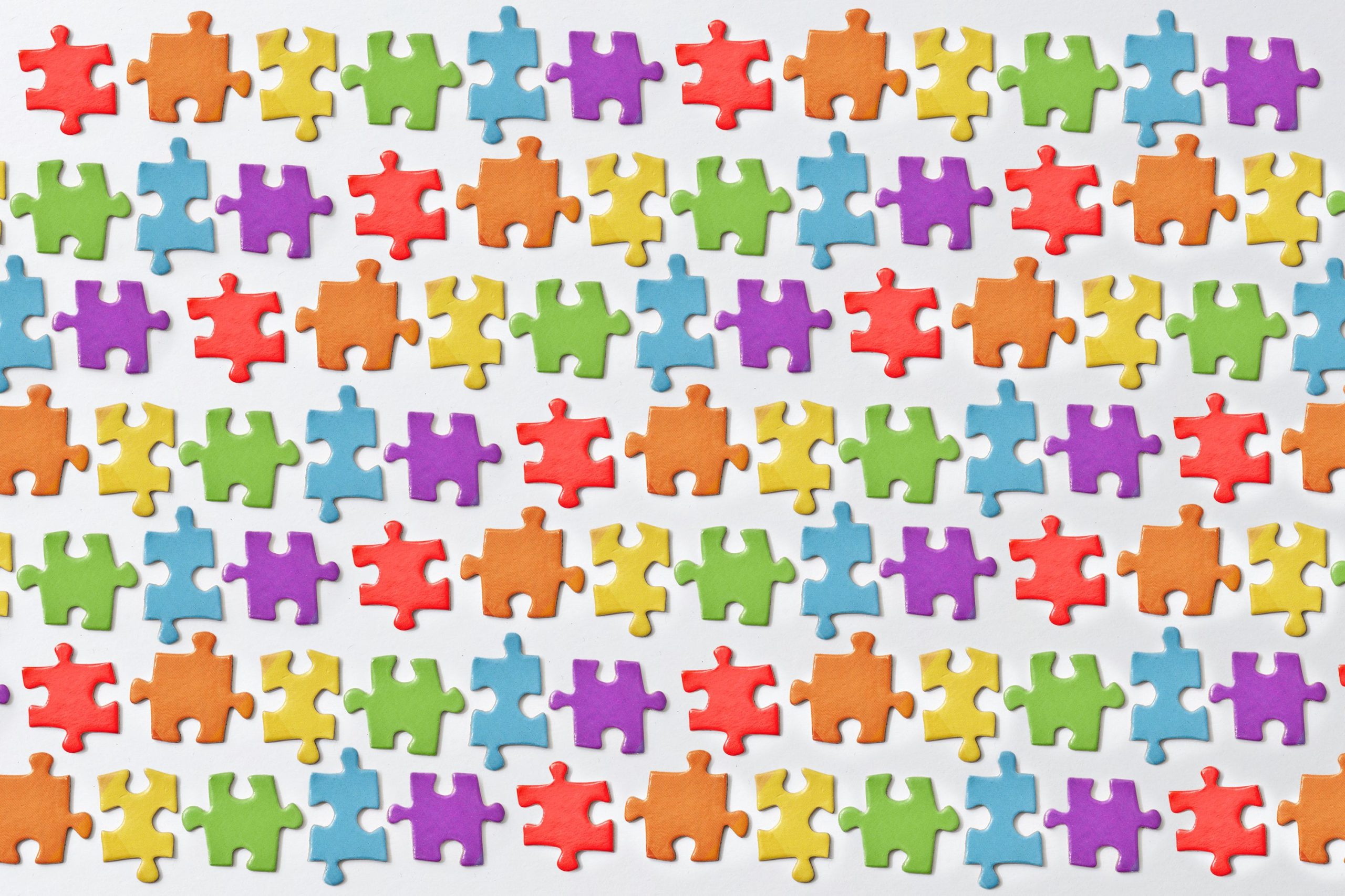 Pièces de puzzle colorées arrangées sur surface blanche