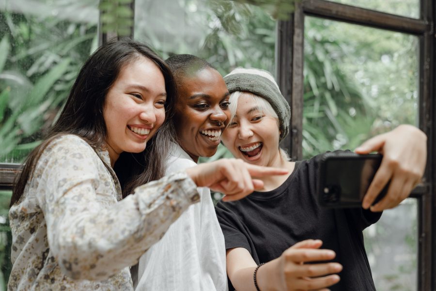 Jeunes femmes riant en voyant un selfie amusant