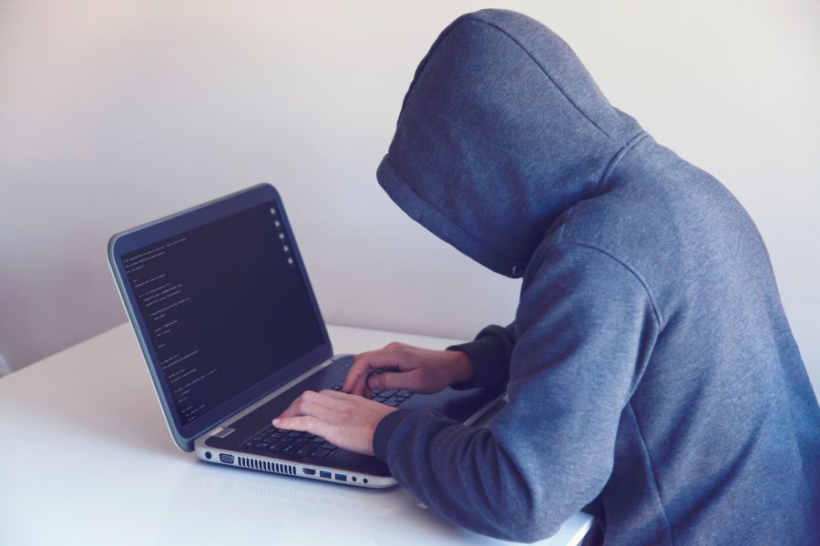 Hacker en hoodie travaillant sur ordinateur portable