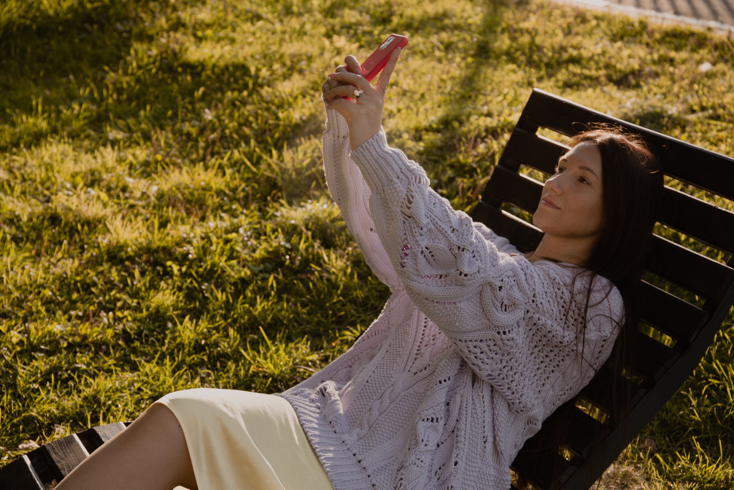 Jeune femme en pull prenant selfie en plein air