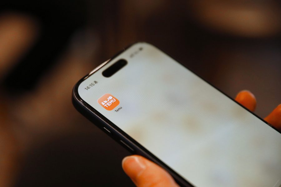 Main tenant smartphone avec icône application shopping