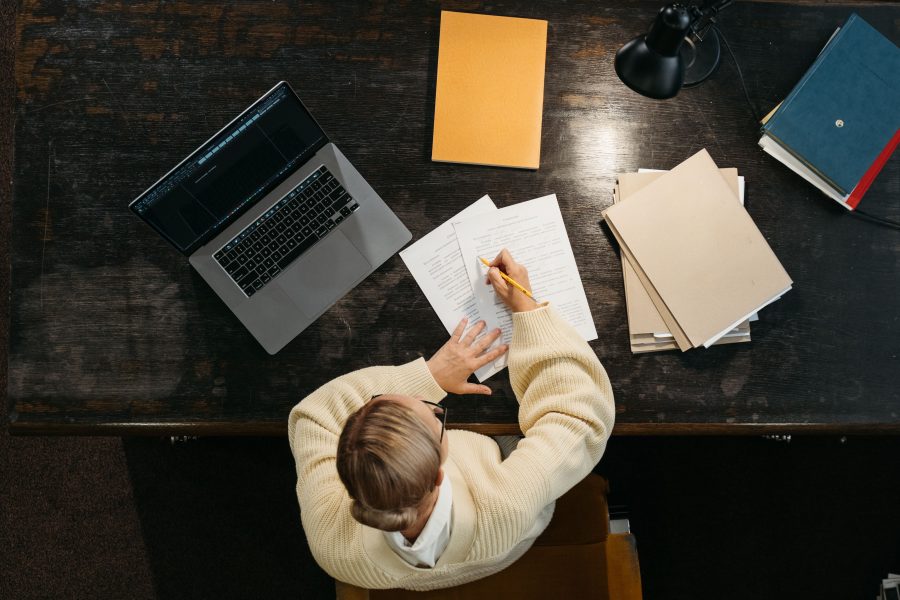Femme écrivant au bureau avec ordinateur portable