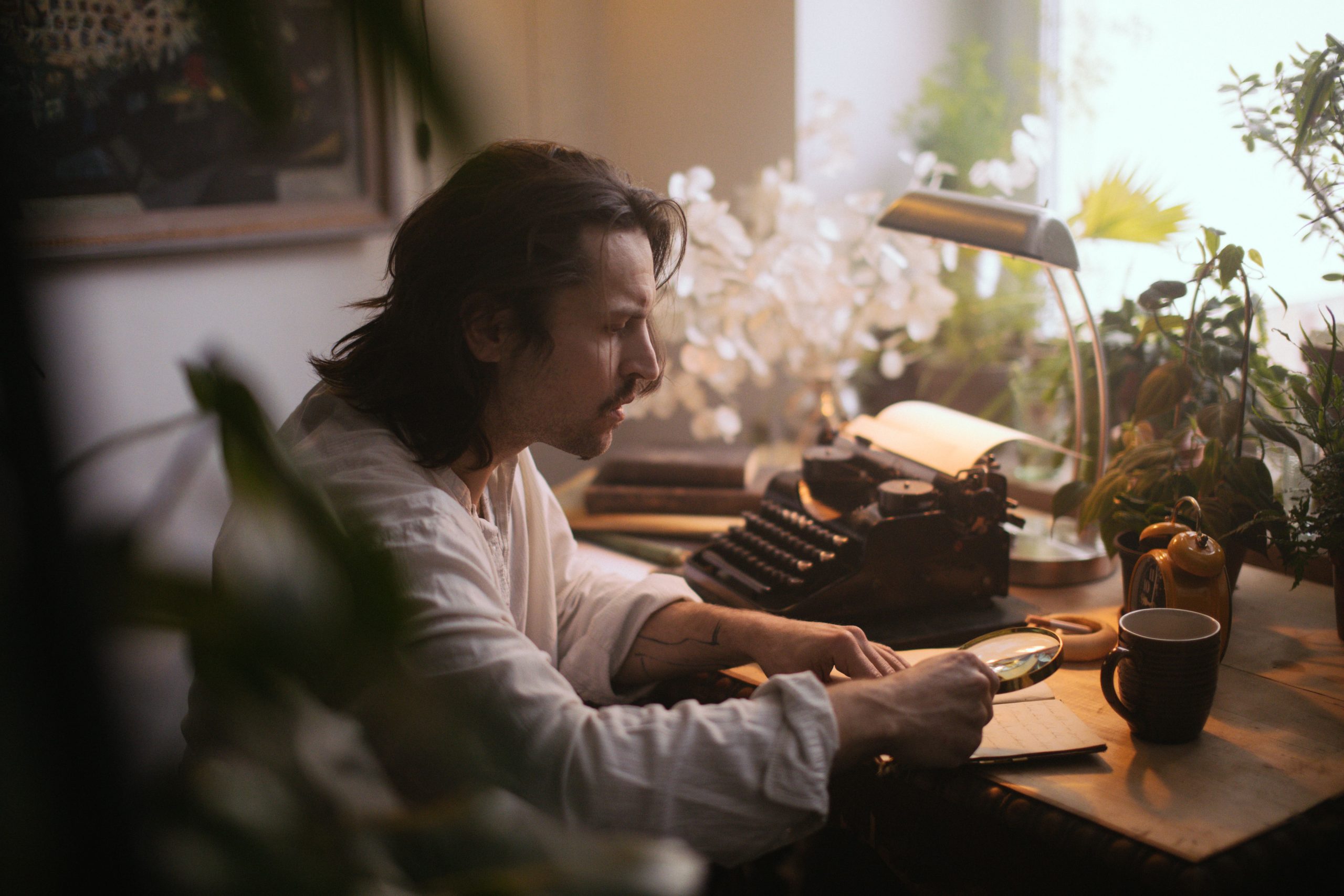 Auteur examinant manuscrit avec loupe
