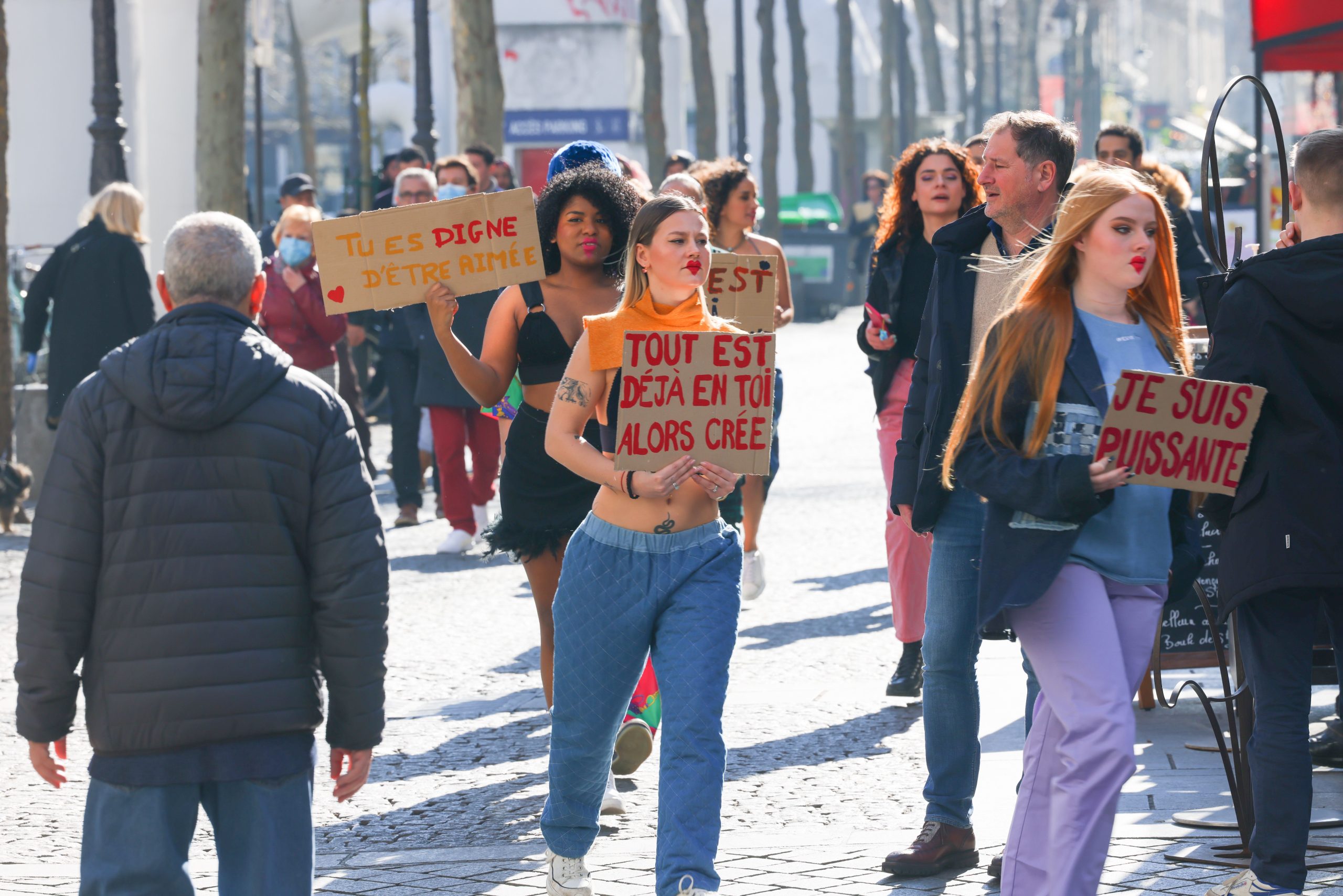 Groupe diverse manifestant dans rue avec pancartes motivantes