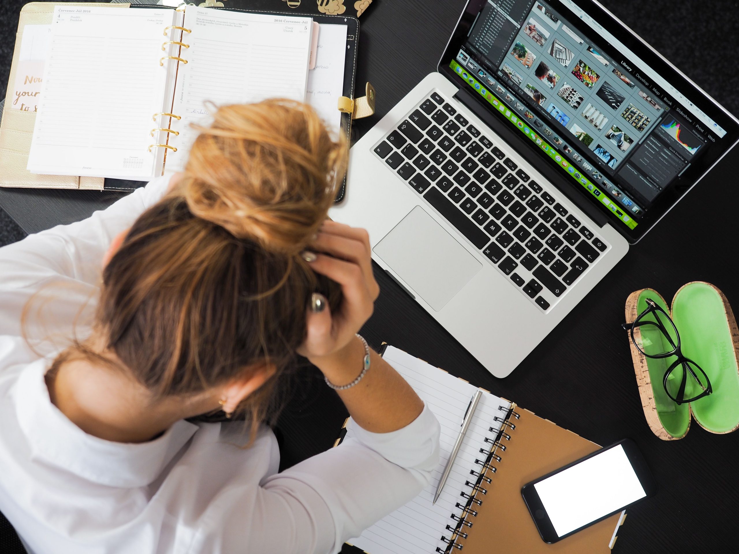 Femme fatiguée à son bureau avec laptop et téléphone