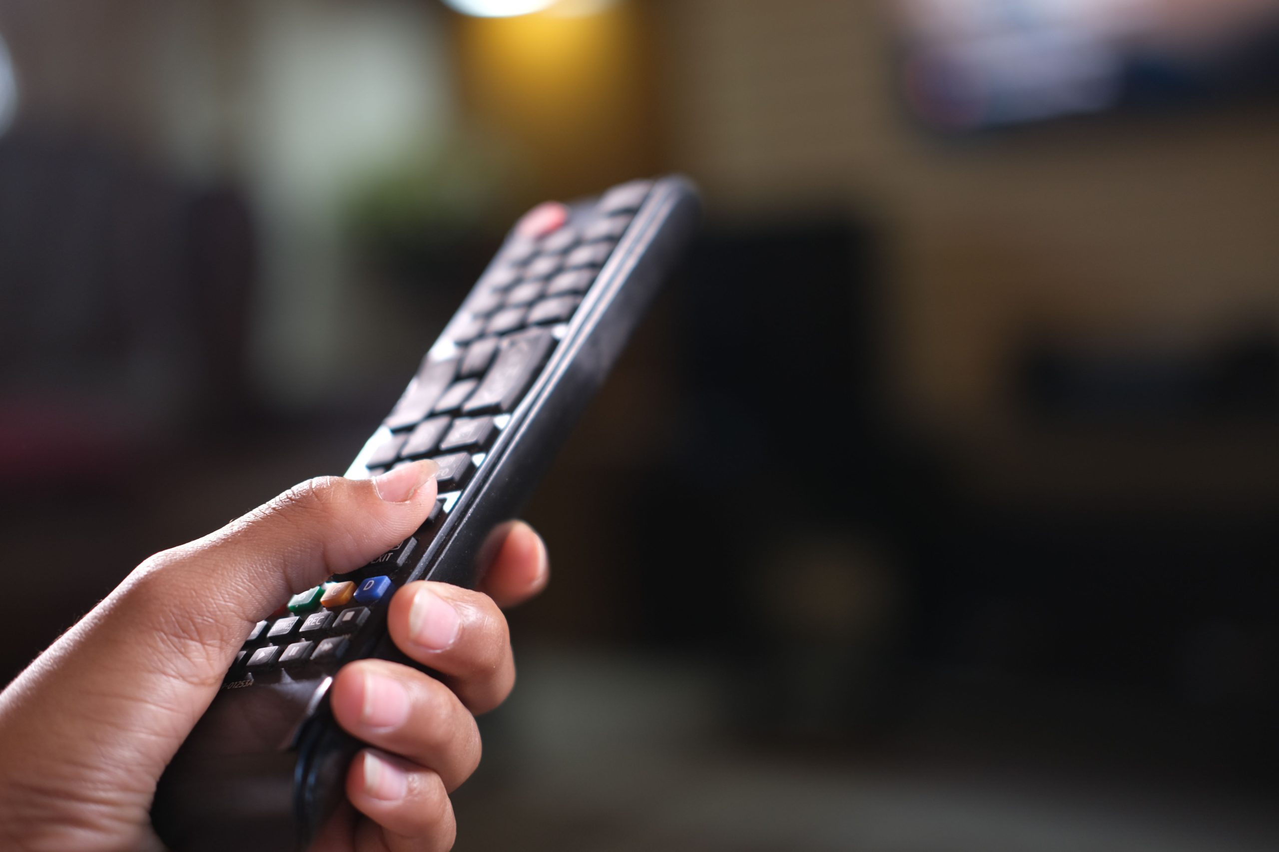 Gros plan main tenant télécommande de télévision