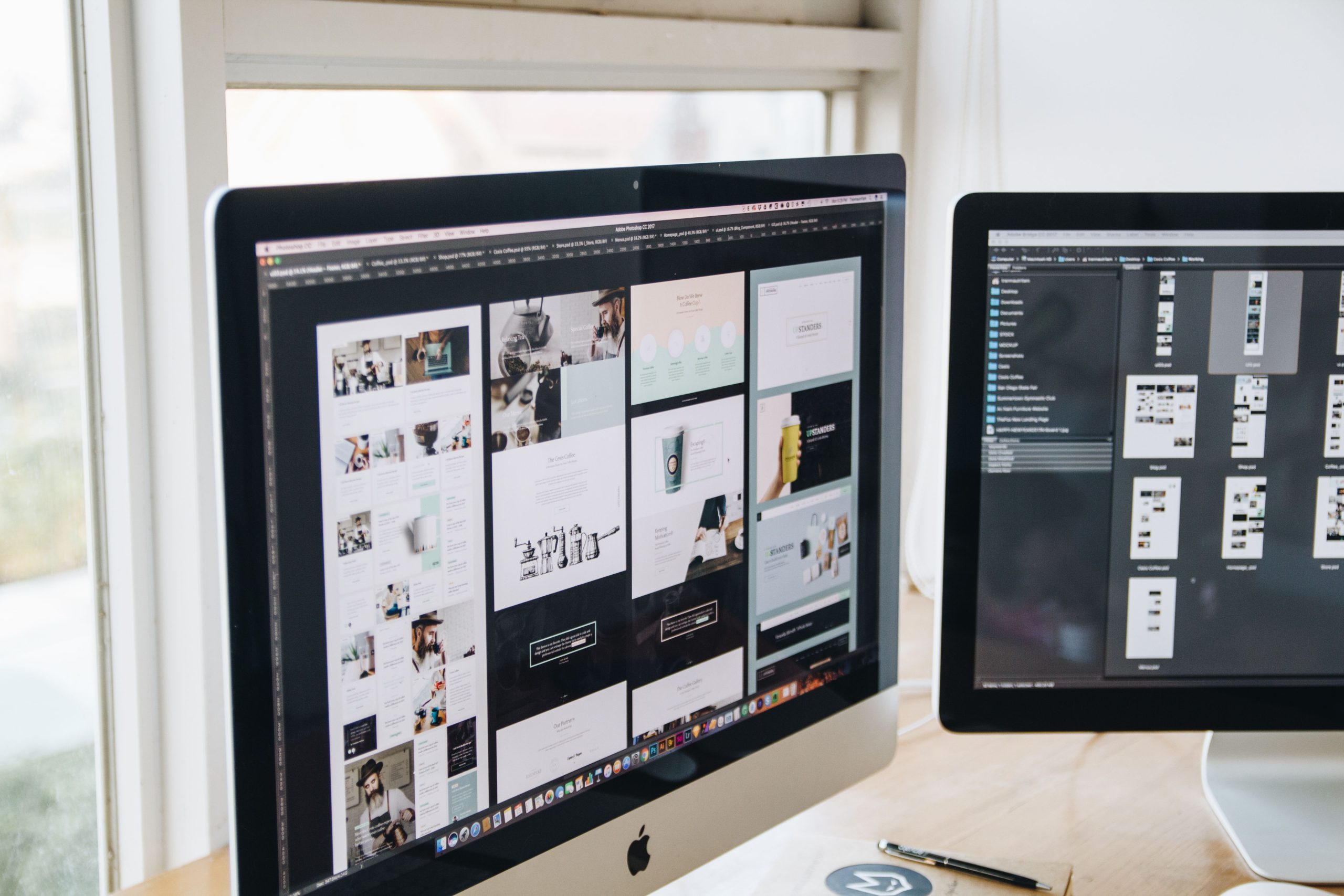Bureau design avec deux ecrans affichant logiciels creation
