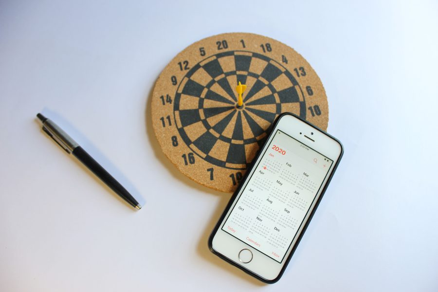 Smartphone avec calendrier et fléchettes sur bureau