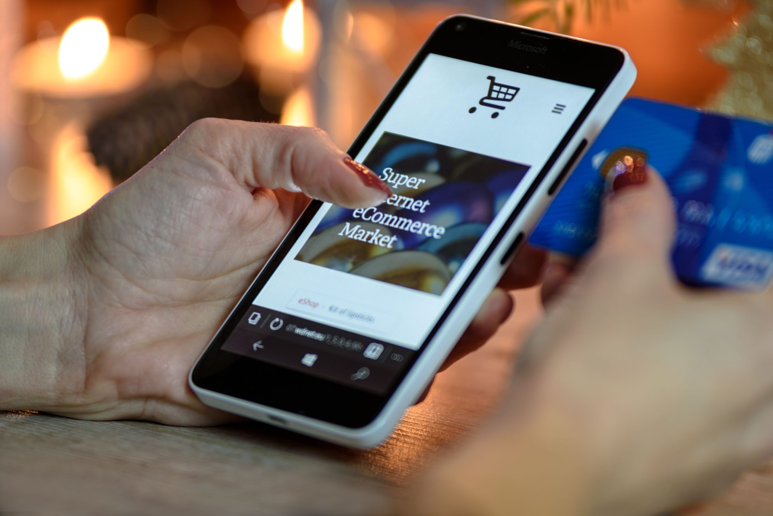 Femme achète en ligne avec carte bancaire en main