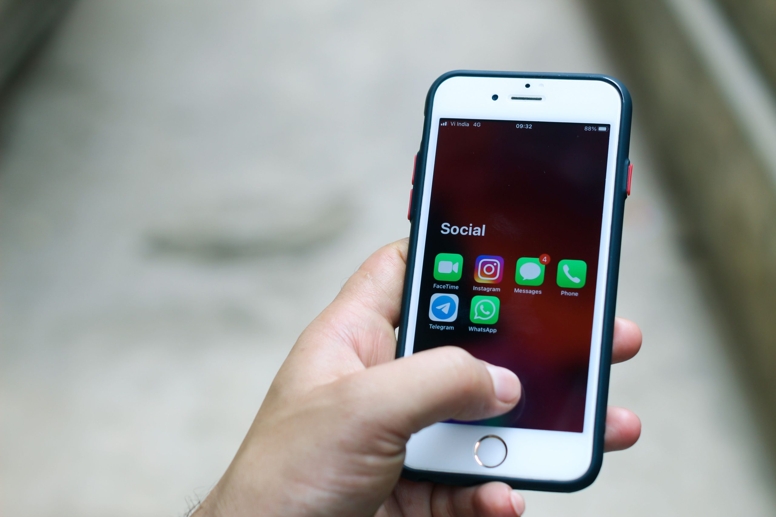 Main smartphone affichant applications communication réseaux sociaux