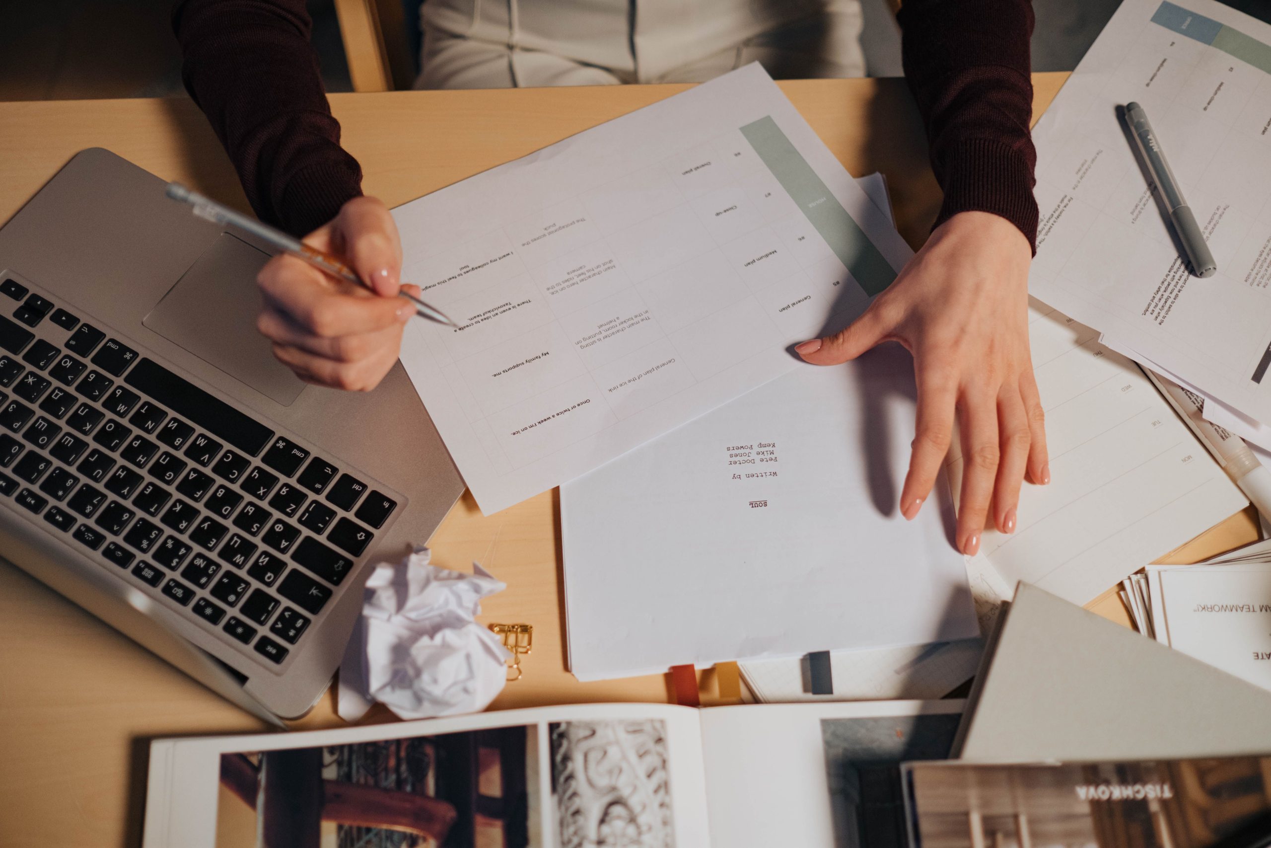 Personne prenant des notes entourée de documents